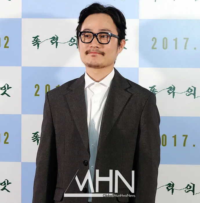 Park Seong-il at a 2017 press event, wearing glasses and a dark suit, in front of a step-and-repeat backdrop.